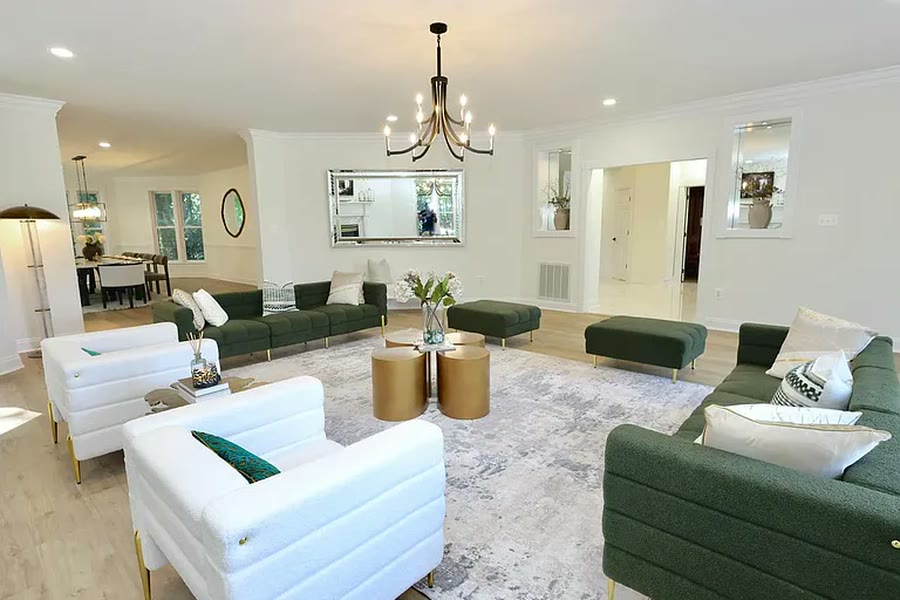 Staged living room with emerald sofas and gold accents