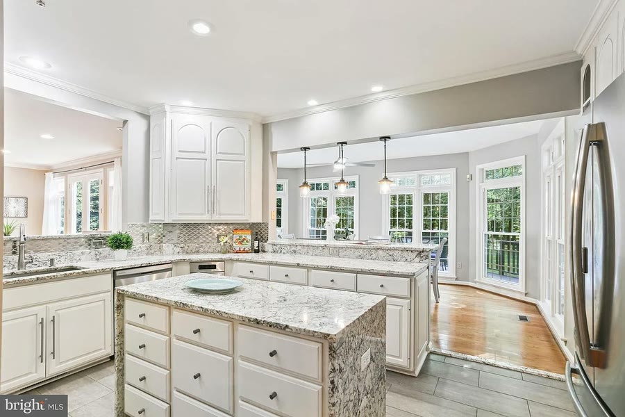 Kitchen with granite counters opening to a sunroom