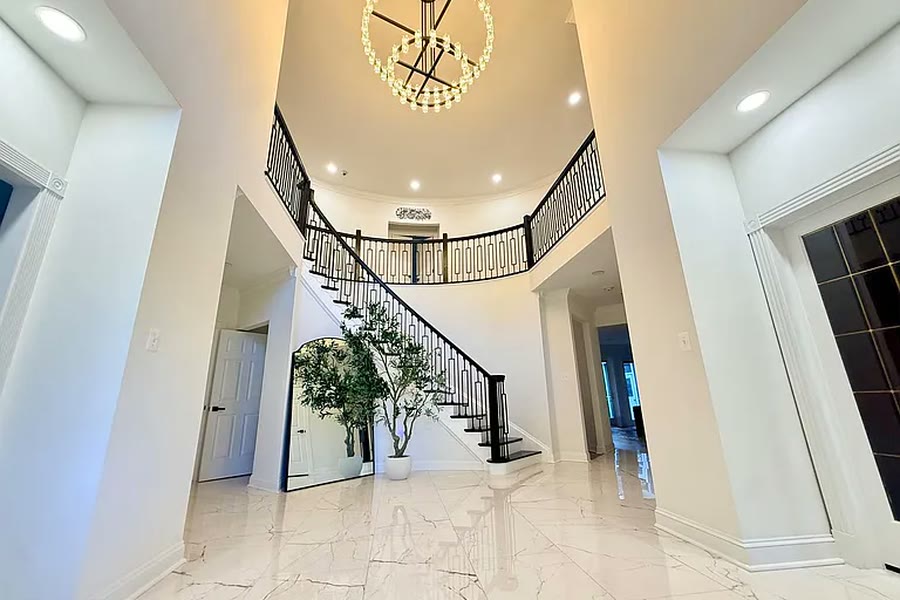 Two-story entry with a curved staircase and marble floor