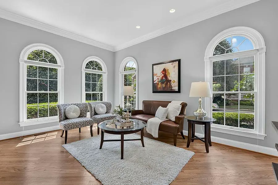 Formal living room with arched windows and hardwood floors